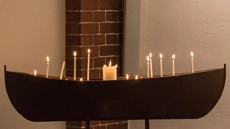 Der Gebetsleuchter in der Petruskirche: ein Boot aus Metall mit Sand gefüllt und Kerzen bestückt.