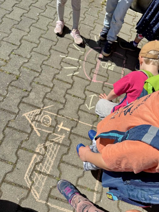 Kinder malen mit Straßenmalkreide eine Kirche