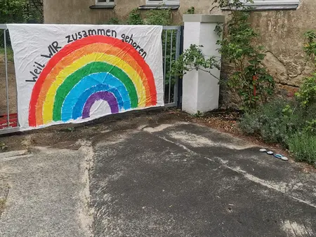 Stoffplakat mit Regenbogen am Kitaeingangstor