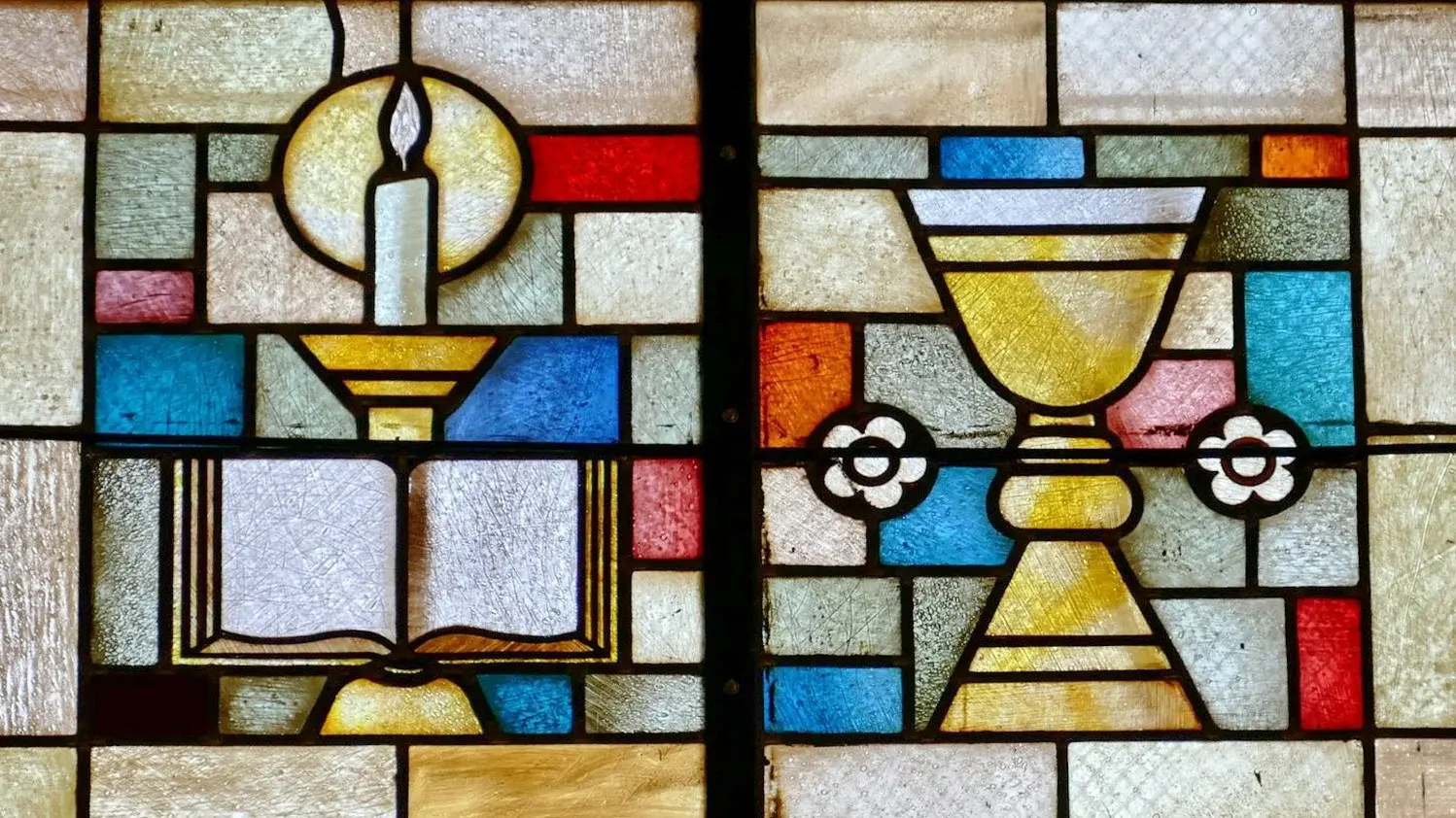 buntes Kirchenfenster mit einem abgebildeten Abendmahlskelch