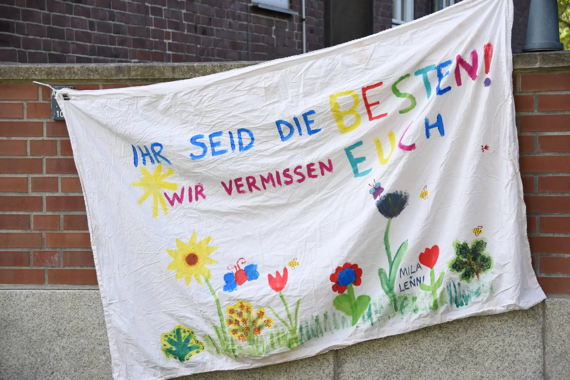 Von Kindern bemaltes Stoffbanner "Wir vermissen euch"